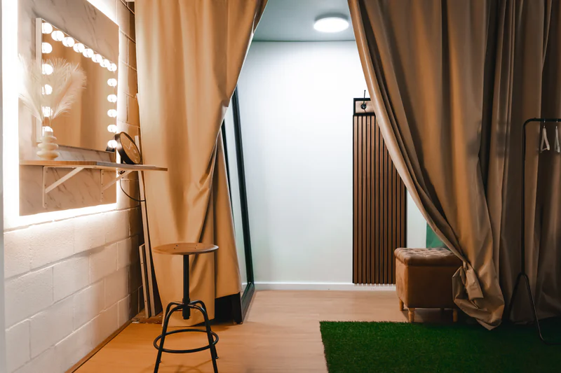 Zona de preparación adyacente al ciclorama con espejo y área de cambio